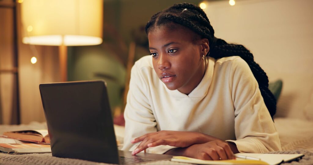Woman researching wrongful termination and retaliation rights on a laptop at home in the evening