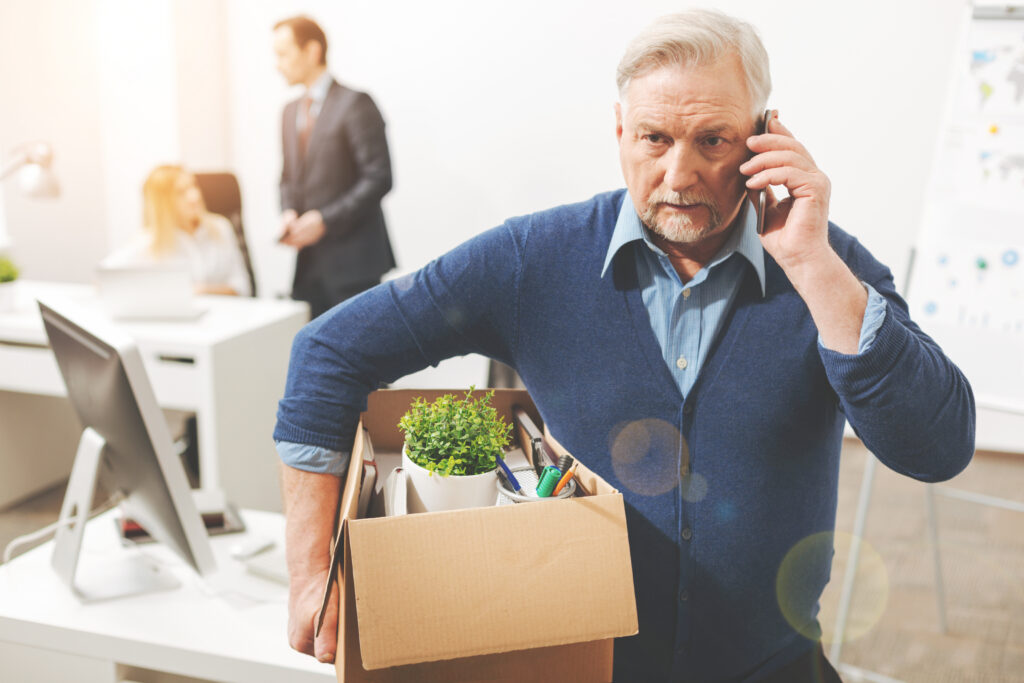Employee carrying a box of belongings out of the office after being fired for no reason in California