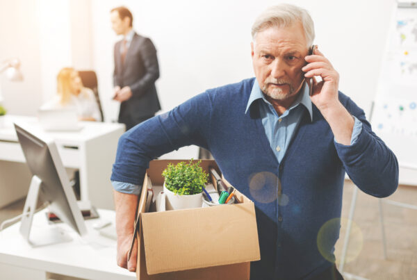 Employee carrying a box of belongings out of the office after being fired for no reason in California
