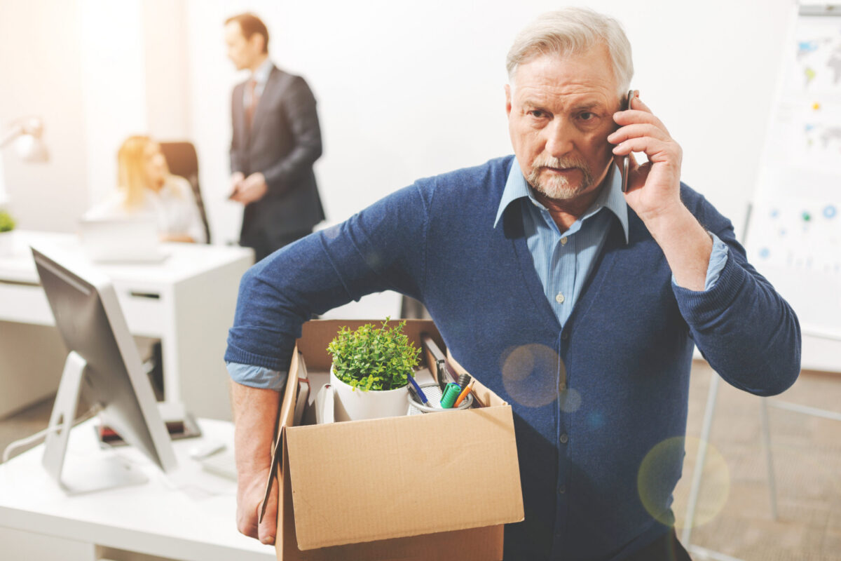 Employee carrying a box of belongings out of the office after being fired for no reason in California
