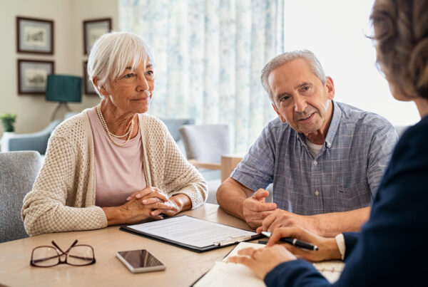 An older couple meeting with an attorney to discuss possibility to sue for wrongful termination, representing the free consultation process at Frontier Law Center.
