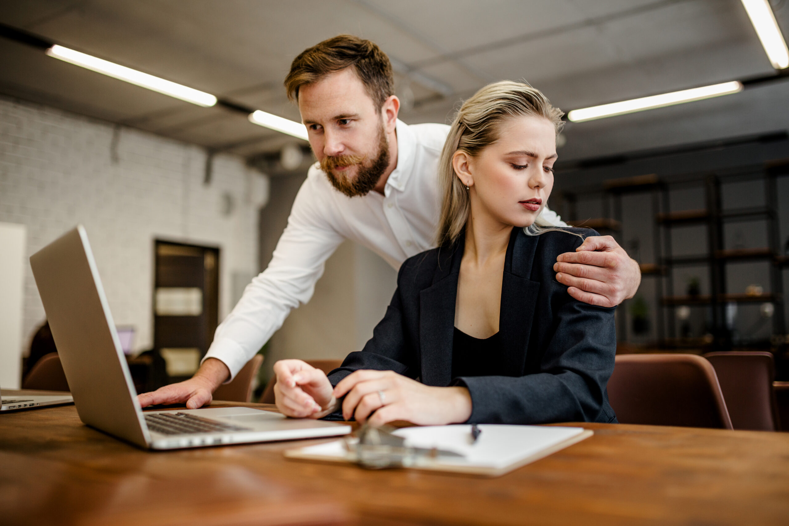 supervisor placing hand on employee shoulder in California workplace depicting quid pro quo sexual harassment