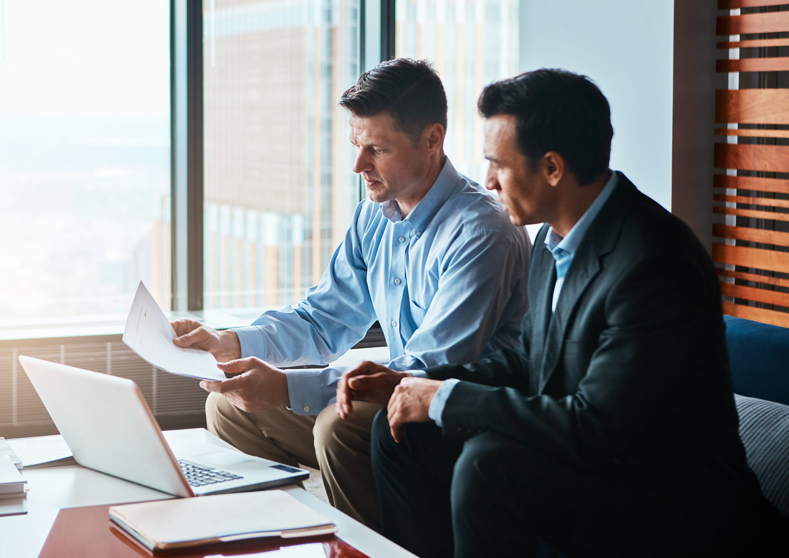 Two professionals reviewing employment documents together during a case consultation meeting