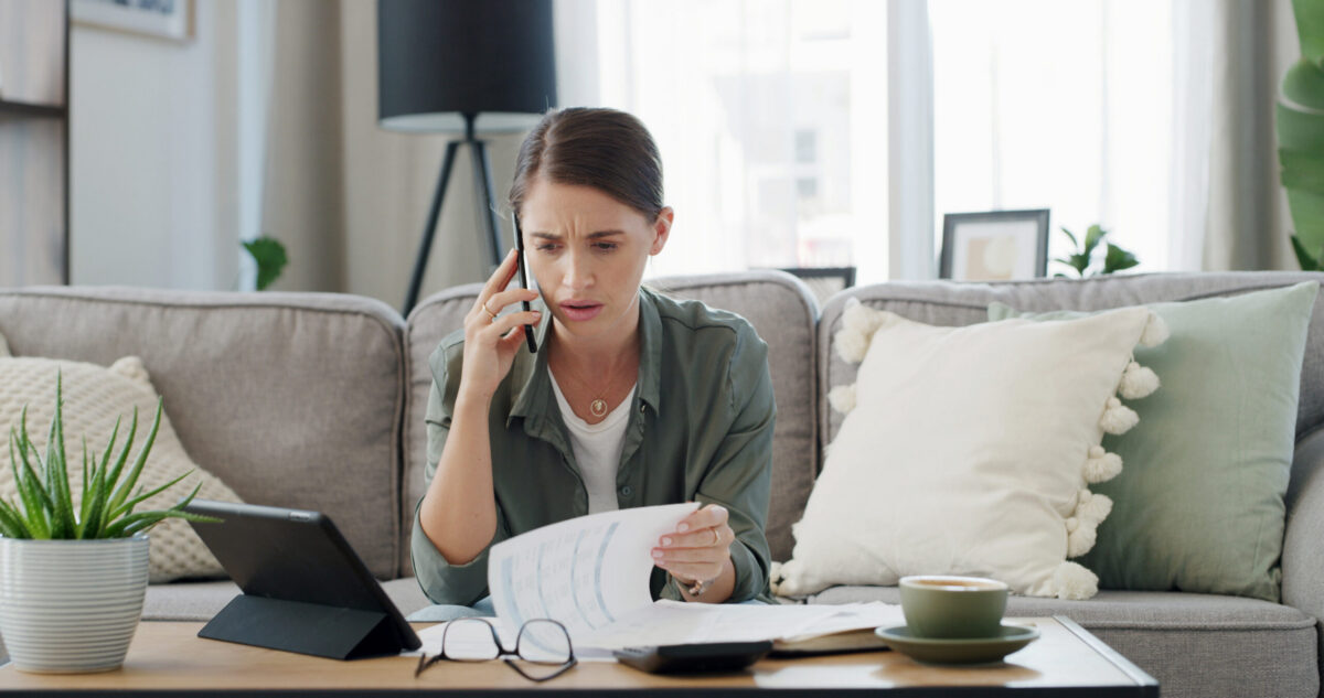 California employee reviewing minimum wage documents at home while on phone call, checking 2027 pay rate