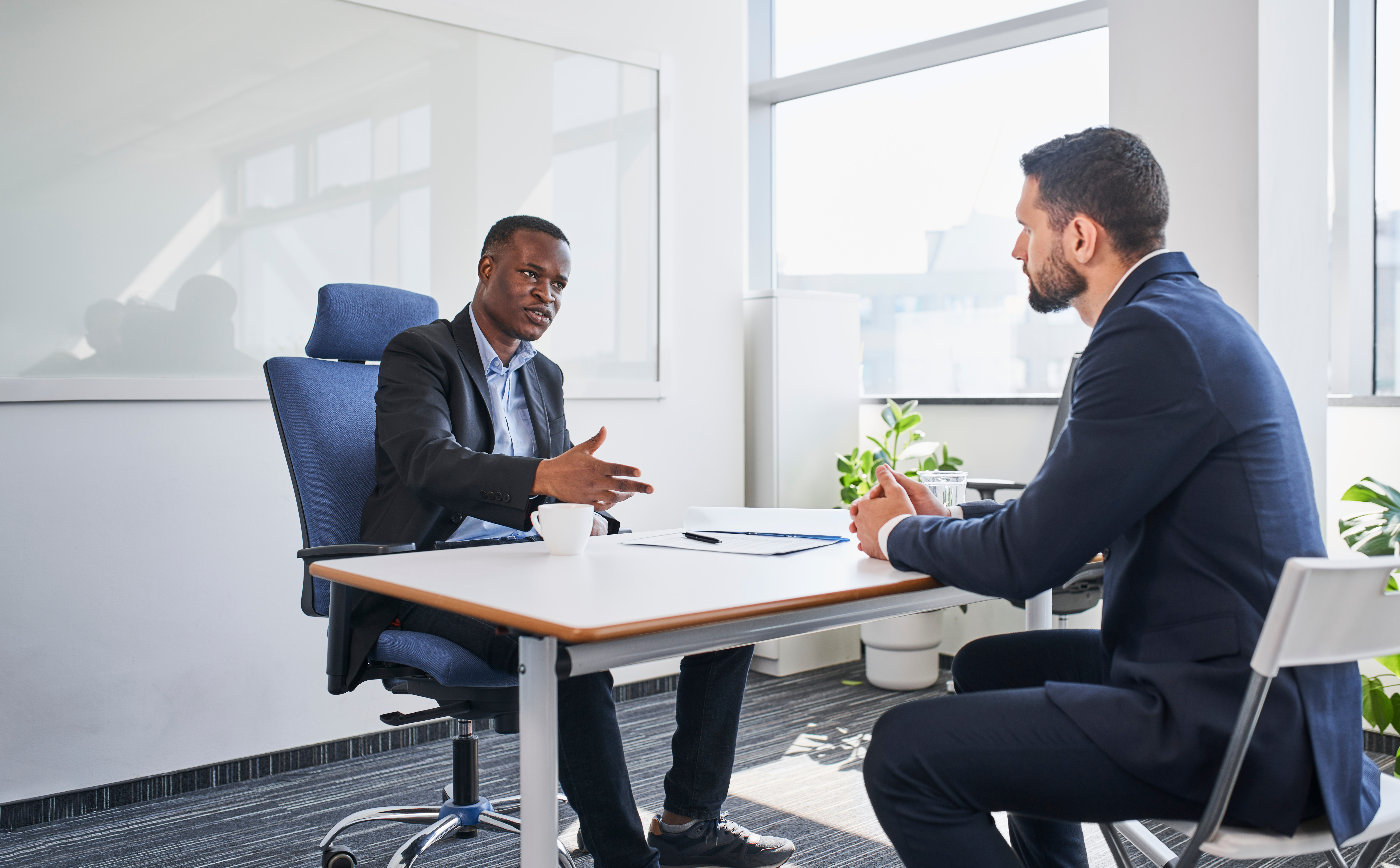 Two professionals discussing the terms of a performance improvement plan during a workplace meeting