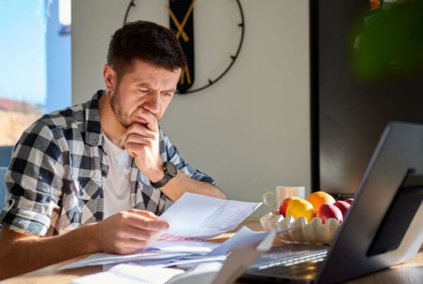 Man reviewing separation documents at home after being fired or laid off in California