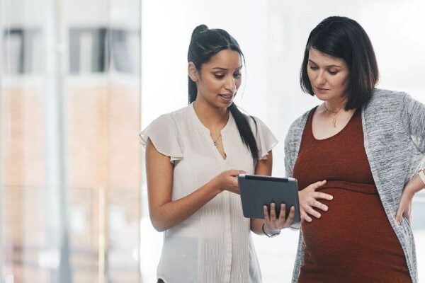 Pregnant Professional Receiving Guidance in a Modern Office