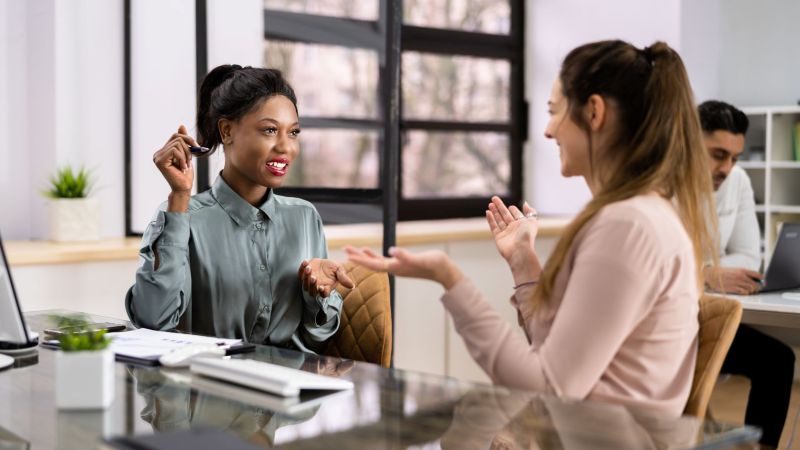 Two Women Having a Professional Conversation in a Modern Office