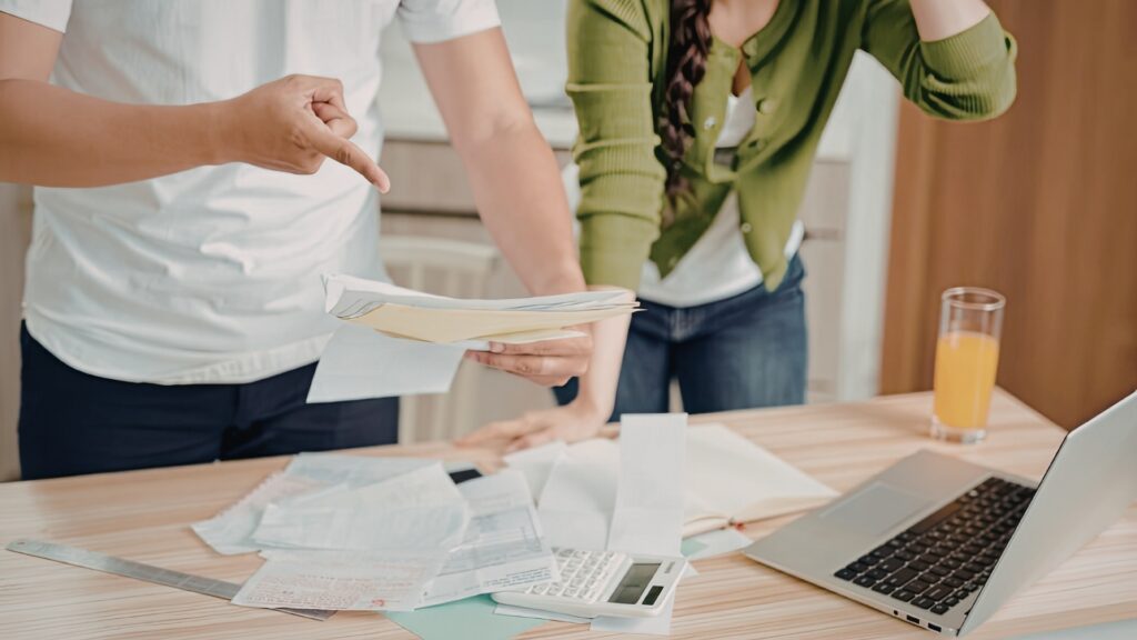 California employee reviewing a pay stub after an employer made changes, calm and focused in warm natural light at a kitchen table
