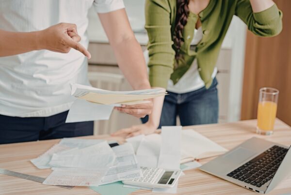 California employee reviewing a pay stub after an employer made changes, calm and focused in warm natural light at a kitchen table