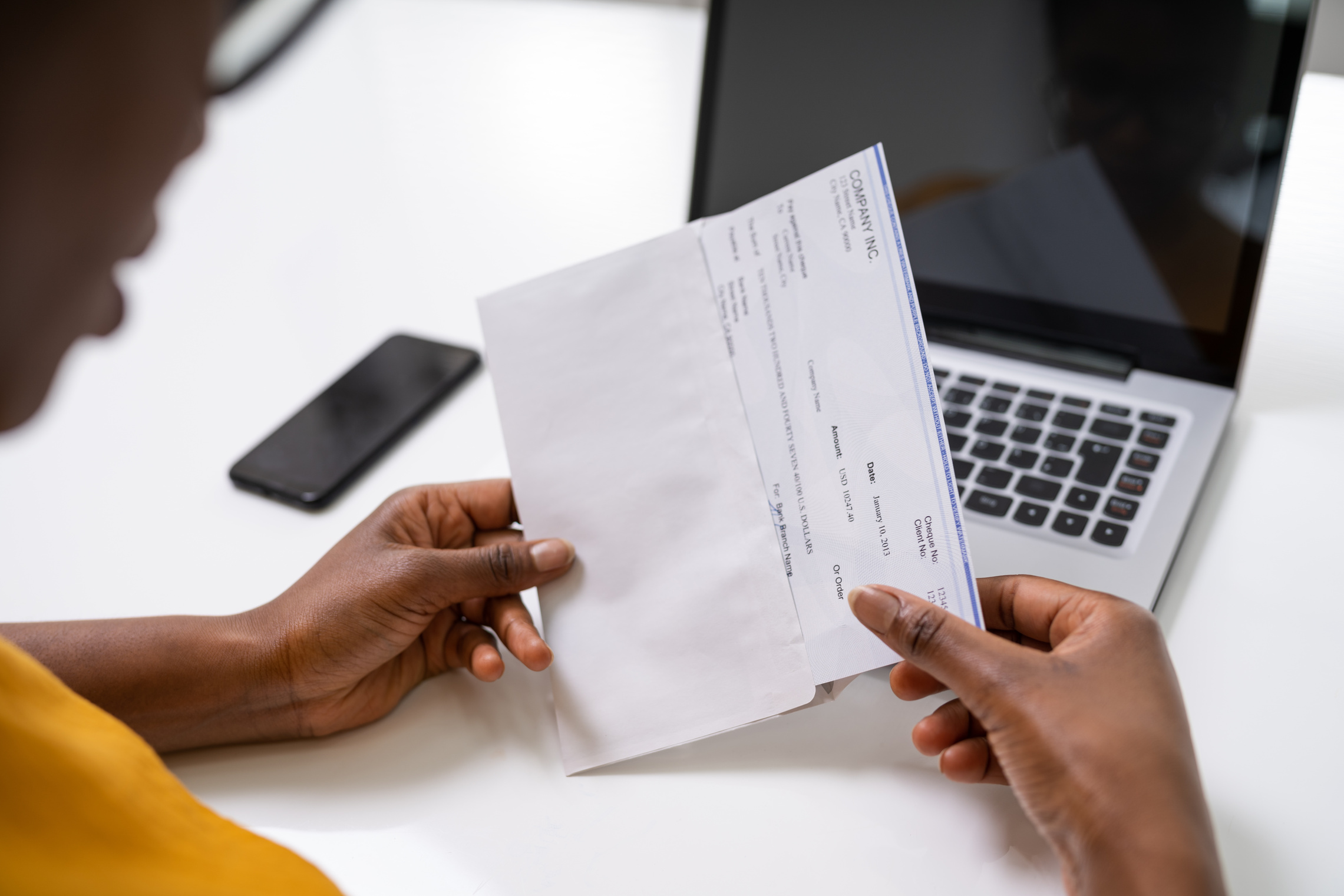 Employee opening a pay envelope to review their paycheck for a potential California minimum wage violation