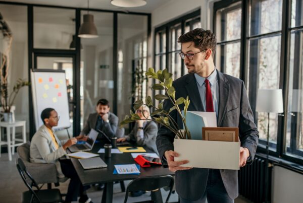Employee carrying a box of personal belongings out of an office after a wrongful termination in California