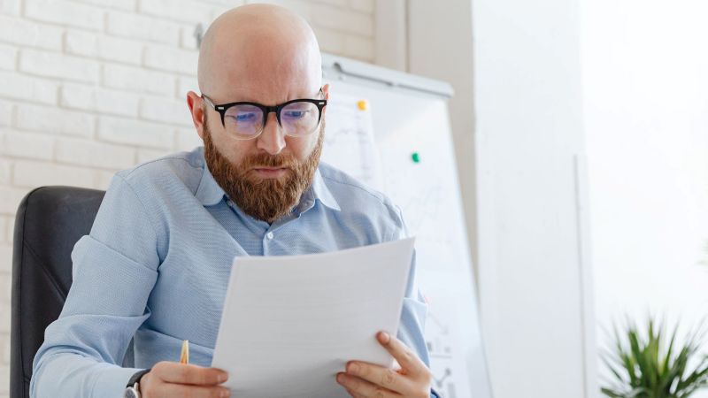 Employee Reviewing Wage Records and Time Documents