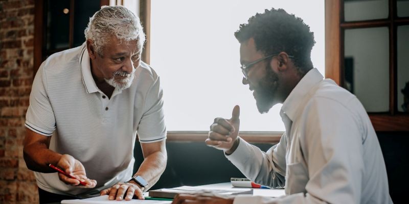 Two colleagues in a workplace discussion — signs of age discrimination dynamics at work in California