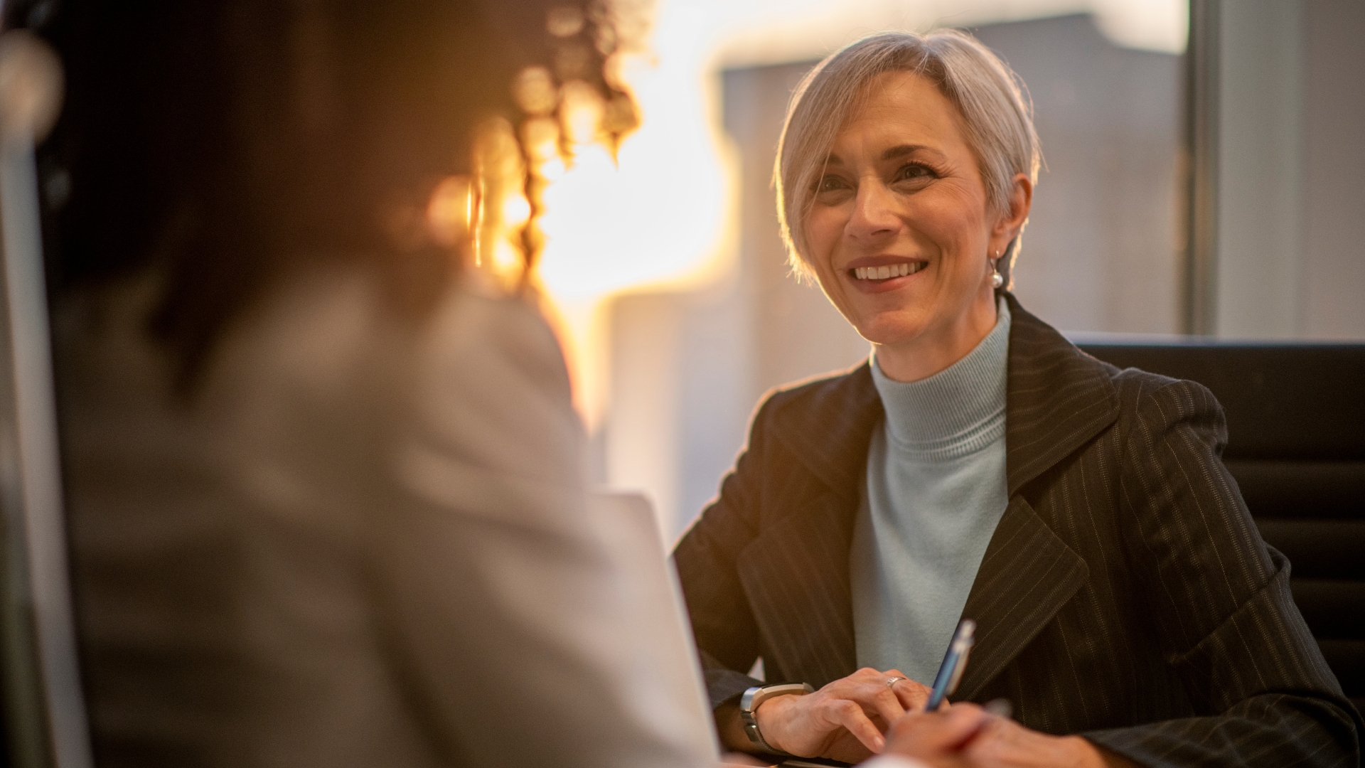 California employee in a candid consultation about employer pay changes, warm golden backlit light