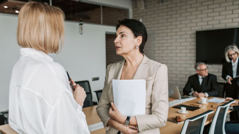 Manager informing an employee her employer can cut her pay rate during a workplace meeting in a California office