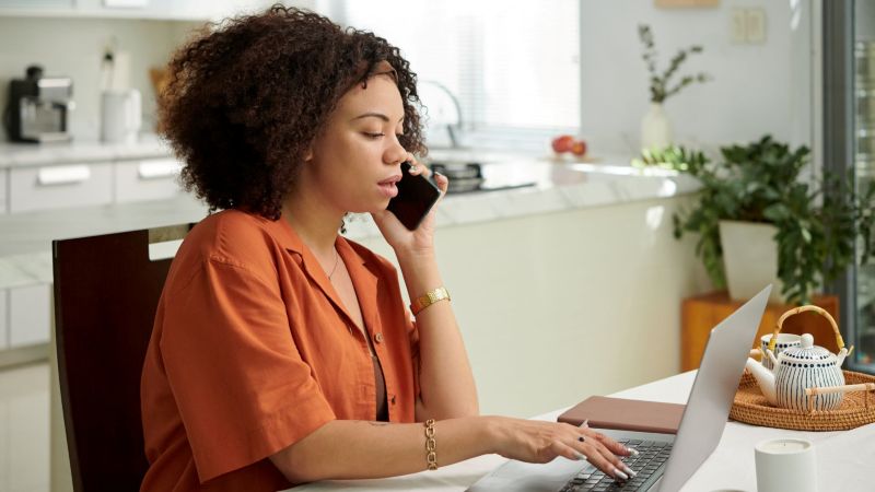 California employee researching a FEHA complaint from home, on the phone with an employment attorney while reviewing information on a laptop