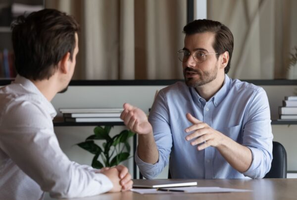 Supervisor making verbal job security promises to an employee in a one-on-one office meeting — the kind of assurances that can create an implied employment contract in California