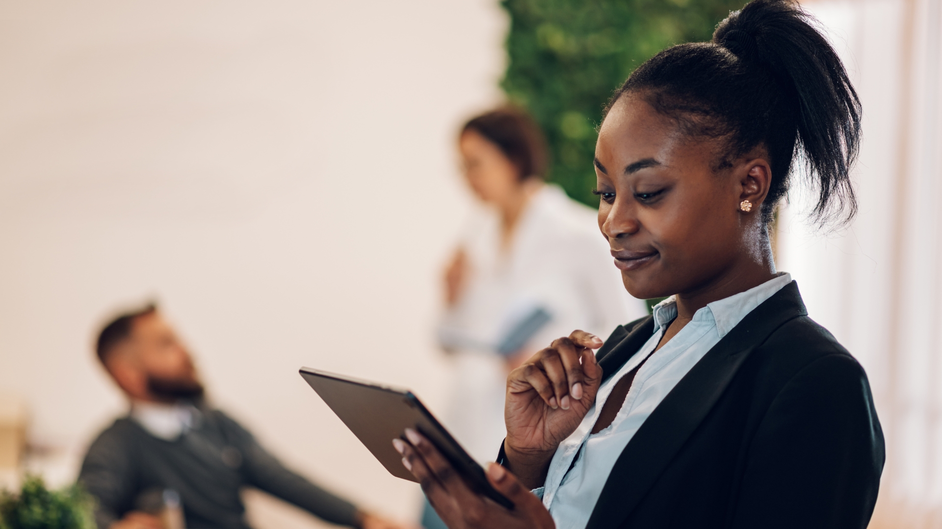 Workplace manager reviewing employee scheduling on a tablet — scheduling errors and miscalculated hours are among the most common causes of unpaid double time pay in California