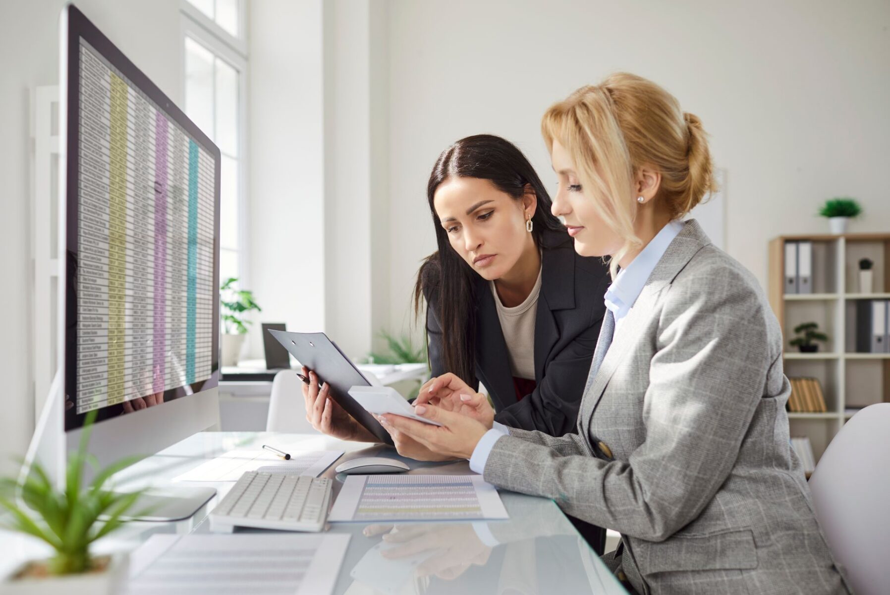 Two professionals reviewing workplace harassment documentation and records together in a California office