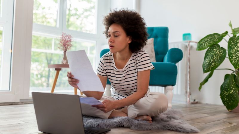 California employee at home reviewing pay documents after her employer cut her pay rate without warning