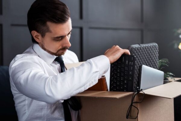 A man packing his personal belongings after being wrongfully fired in California