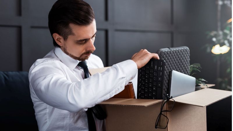 A man packing his personal belongings after being wrongfully fired in California