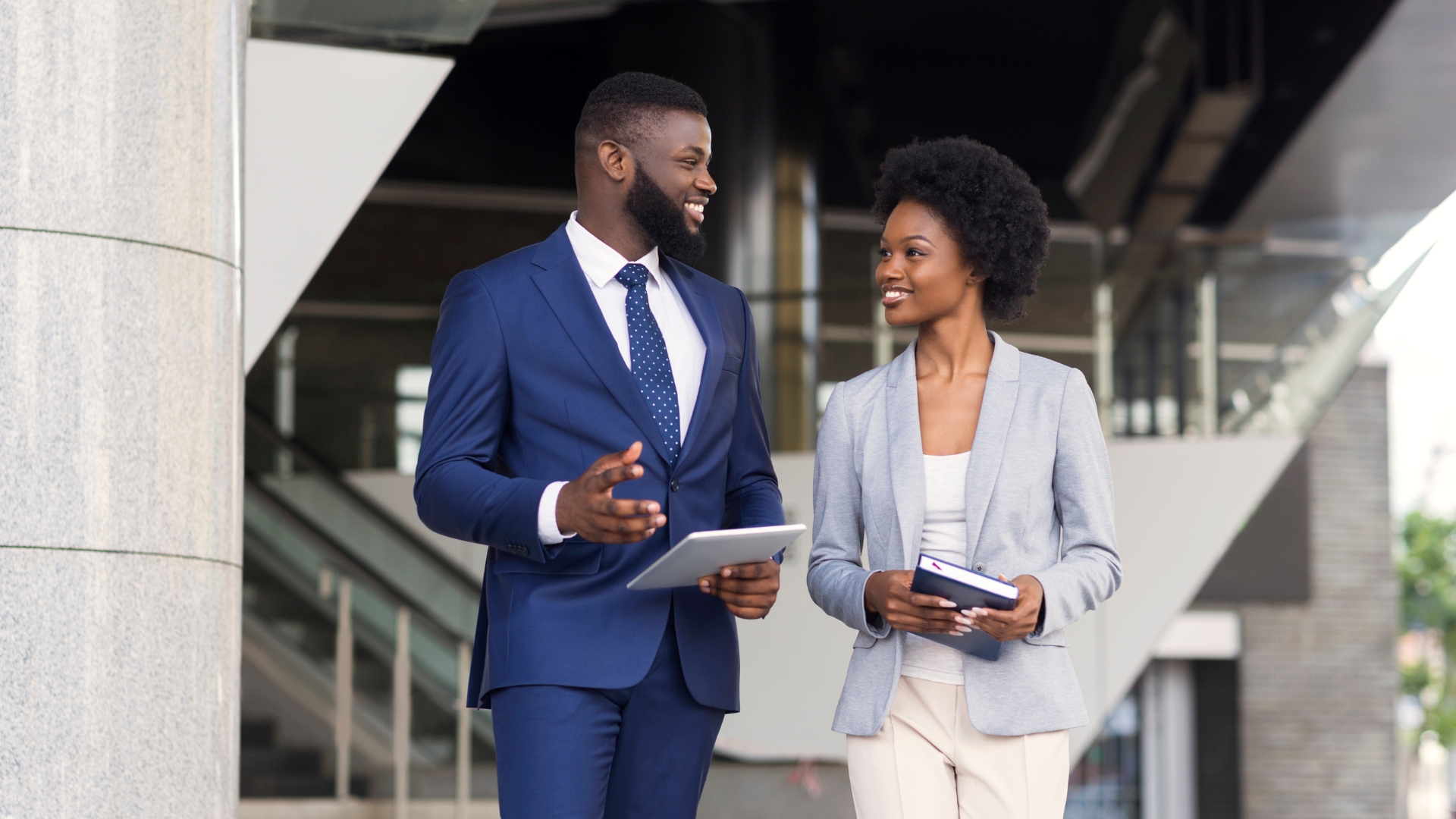 Two professionals discussing a workplace retaliation settlement outside a California office building