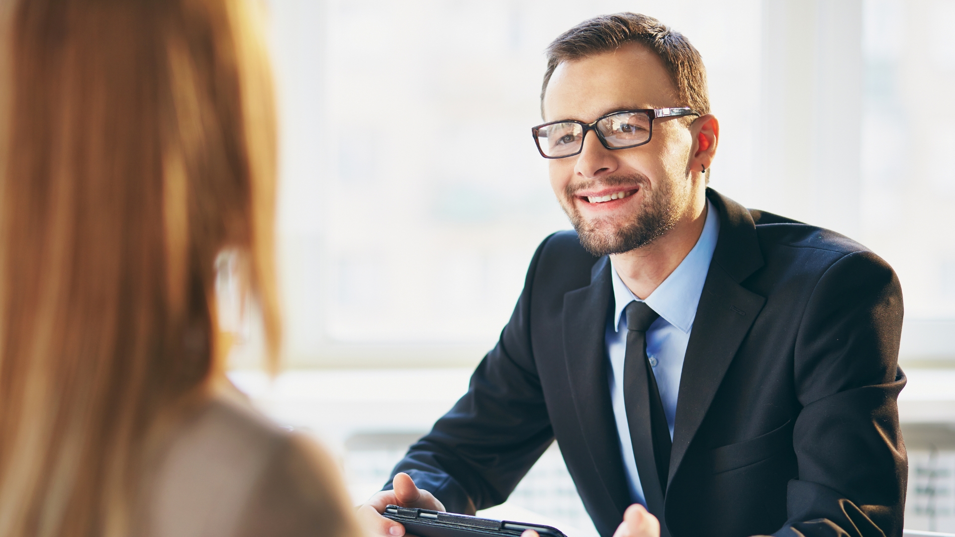 Employment attorney smiling while reviewing a case with a client during a free consultation