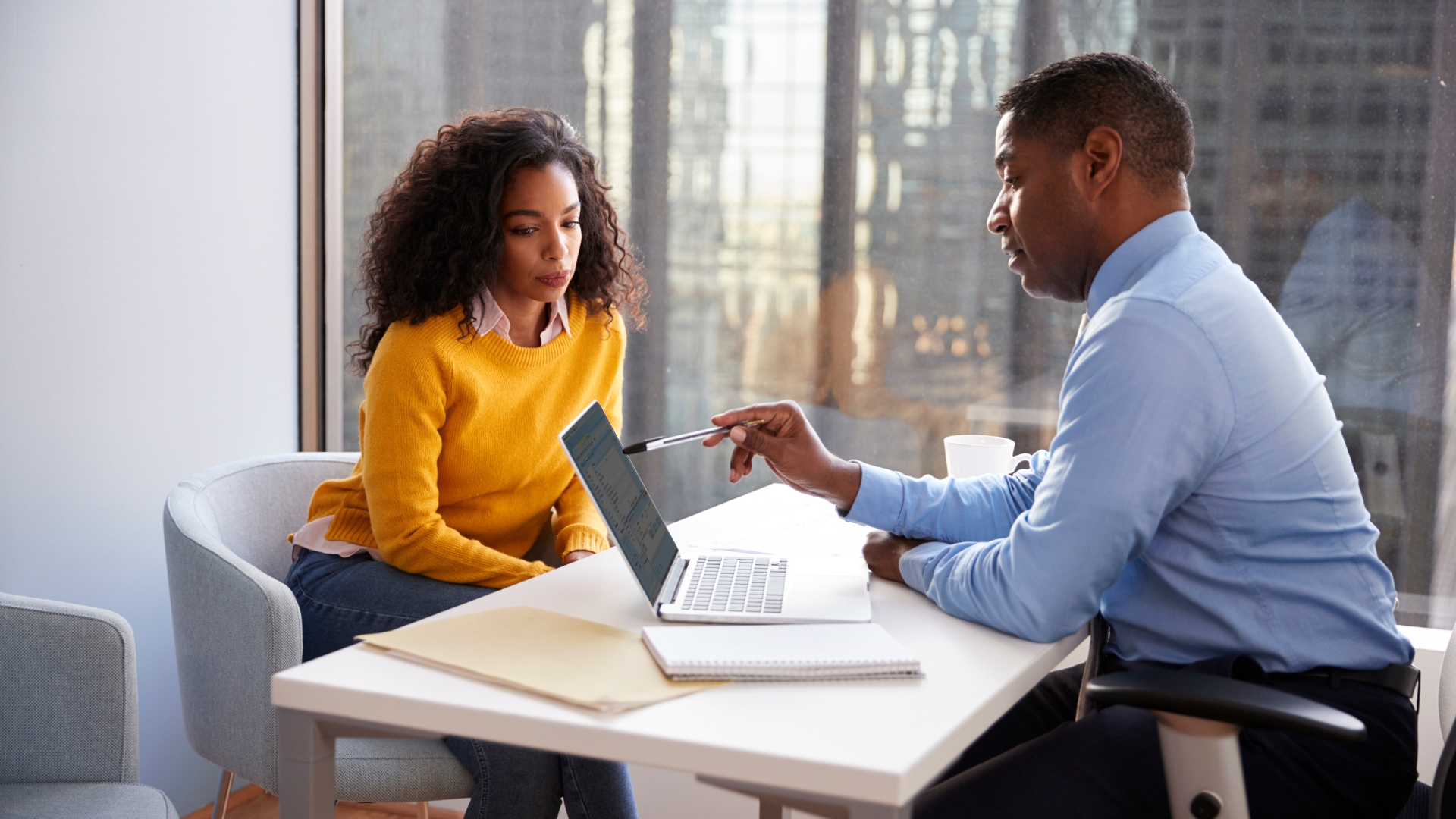 Employee sitting across from manager during tense performance review in an illegal hostile work environment