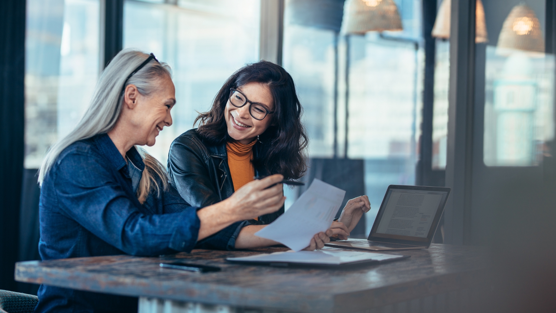 Two coworkers reviewing a pay document, addressing pay gaps under new California labor laws