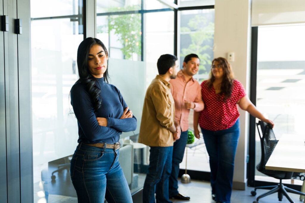 Employee standing apart from coworkers, a pattern that can lead to a gender discrimination lawsuit