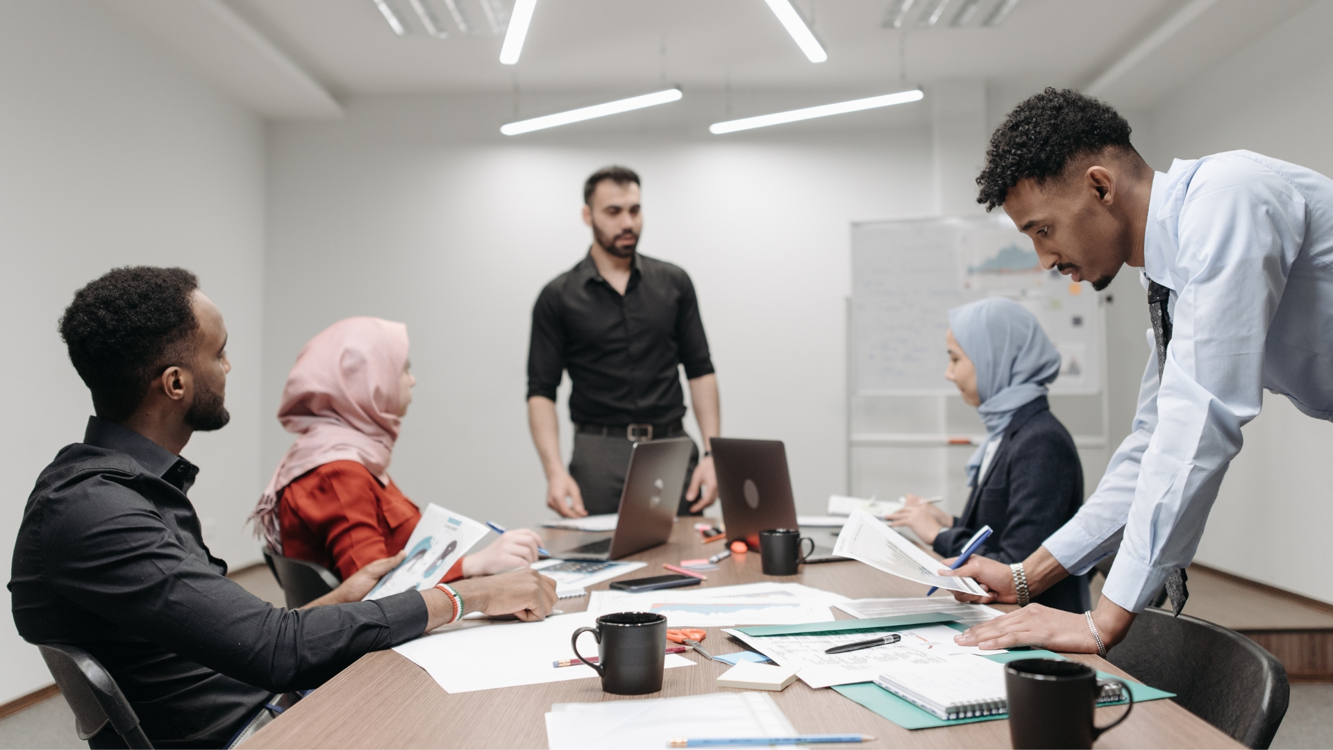 Employees wearing hijabs during a team meeting in a California office, an example of the religious dress protected from religious discrimination in the workplace