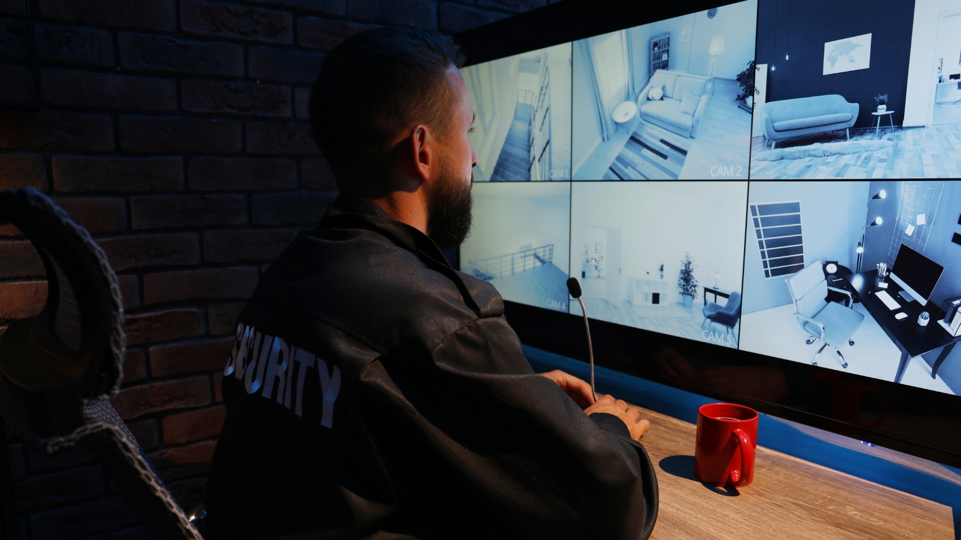 A security guard monitors surveillance cameras during a 12-hour overnight shift, a schedule common in California workplaces with specific overtime pay requirements