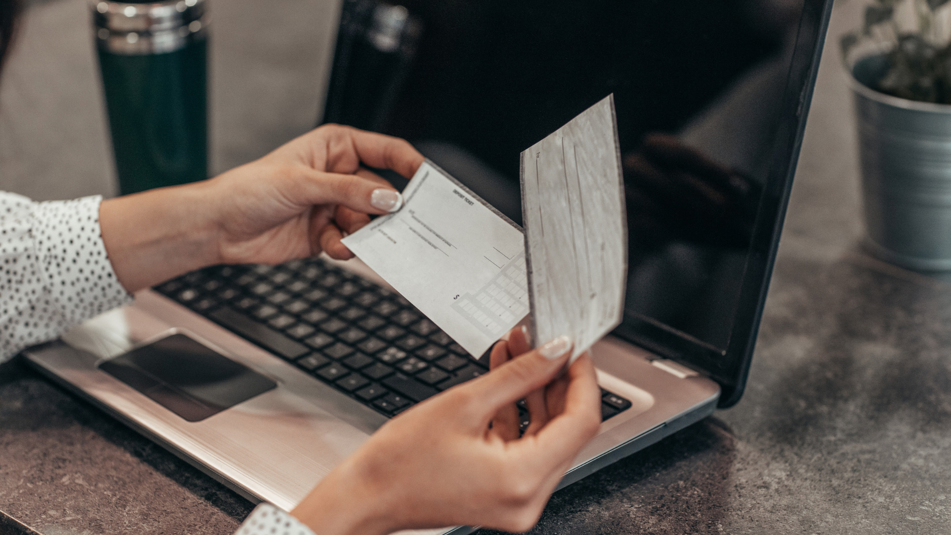 A California employee reviews a paycheck next to an open laptop
