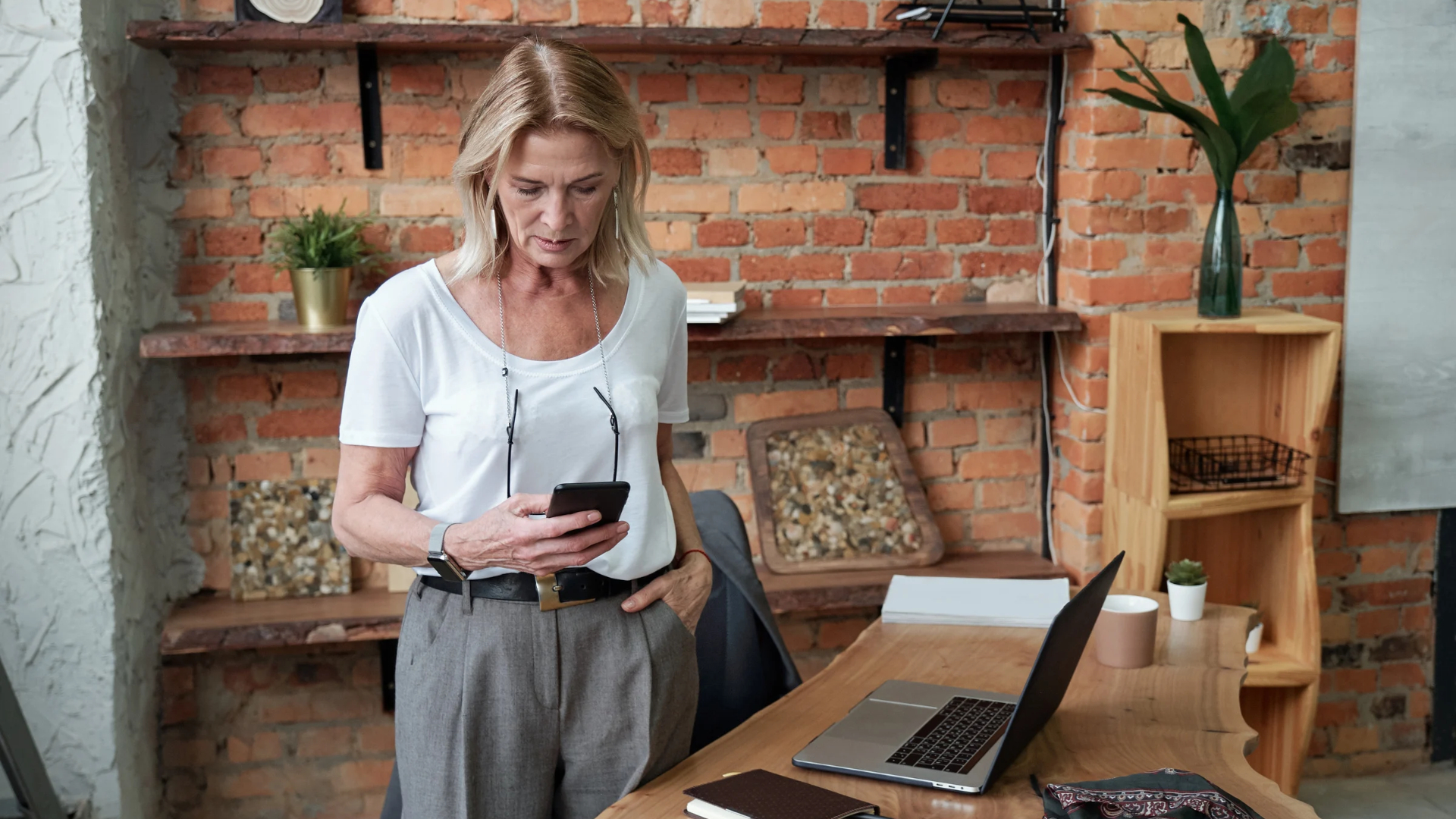 Employee reading a message on her phone at her desk, recognizing a quid pro quo harassment example