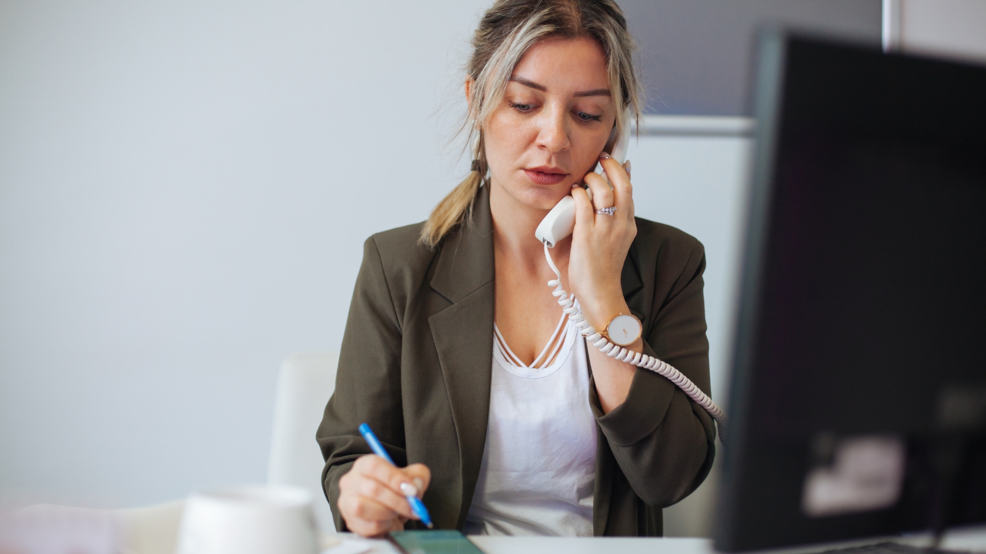 Employee on the phone taking notes while learning how to report sexual harassment at work