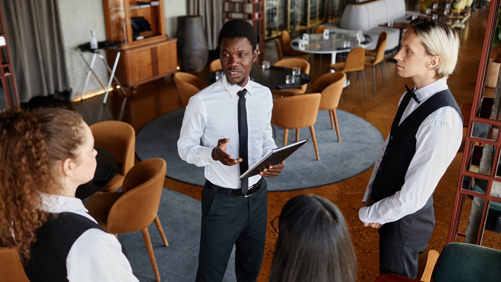 Restaurant supervisor briefing serving staff before a shift, a common Orange County wage and hour claim setting