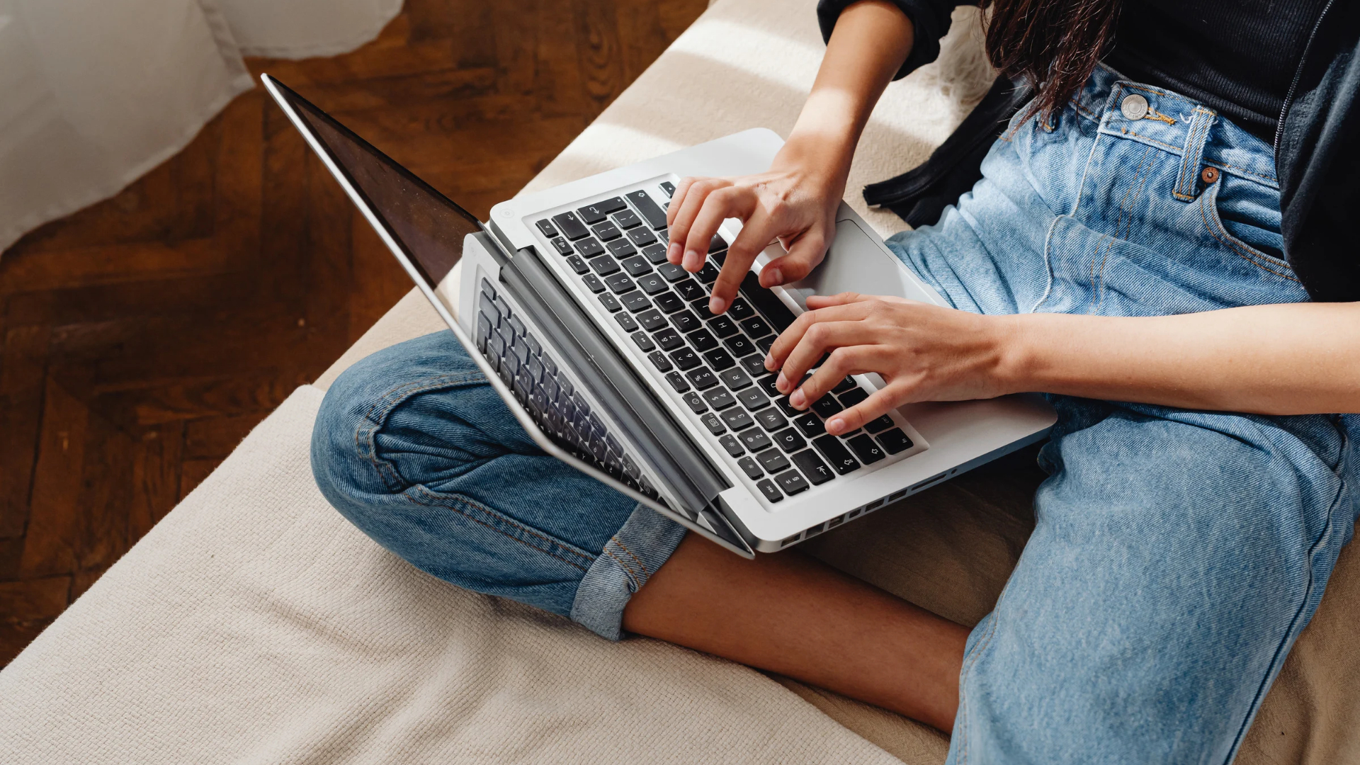 Employee typing on a laptop at home in the evening, documenting a quid pro quo harassment situation away from work