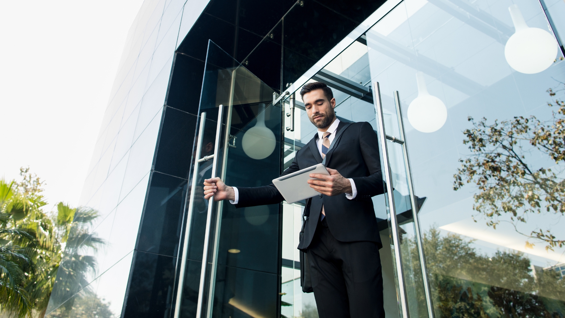 California professional exiting an office building while reviewing documents after workplace discrimination